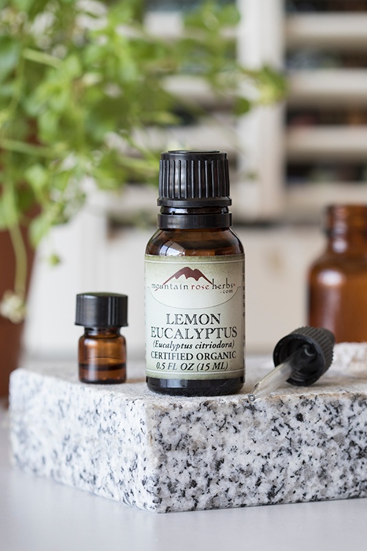 .5 oz bottle of lemon eucalyptus essential oil with small bottle and dropper on granite counter