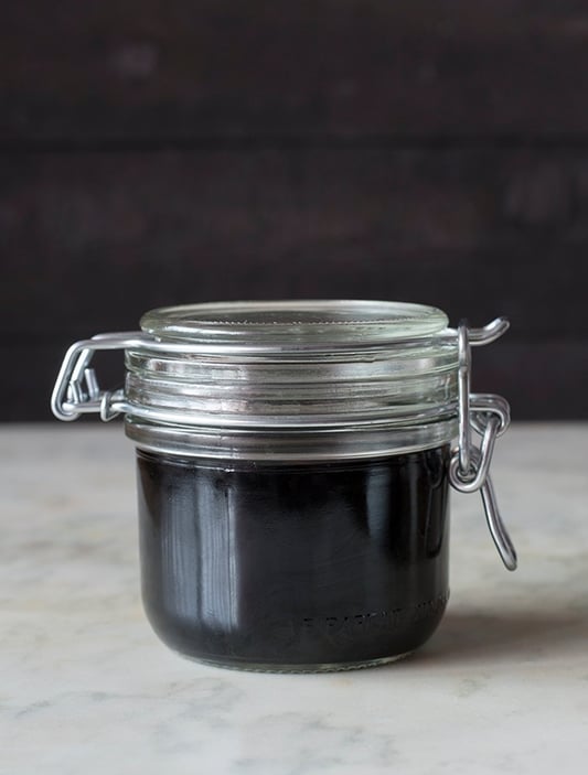 glass pantry jar filled with elderberry syrup 