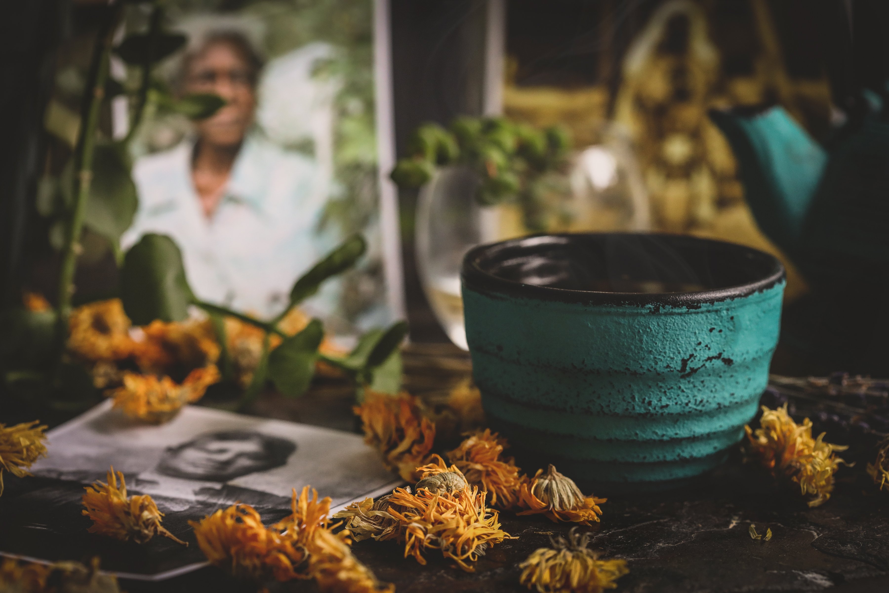 Cast Iron tea cup with flowers and historical photos of folk herbalists of color. 