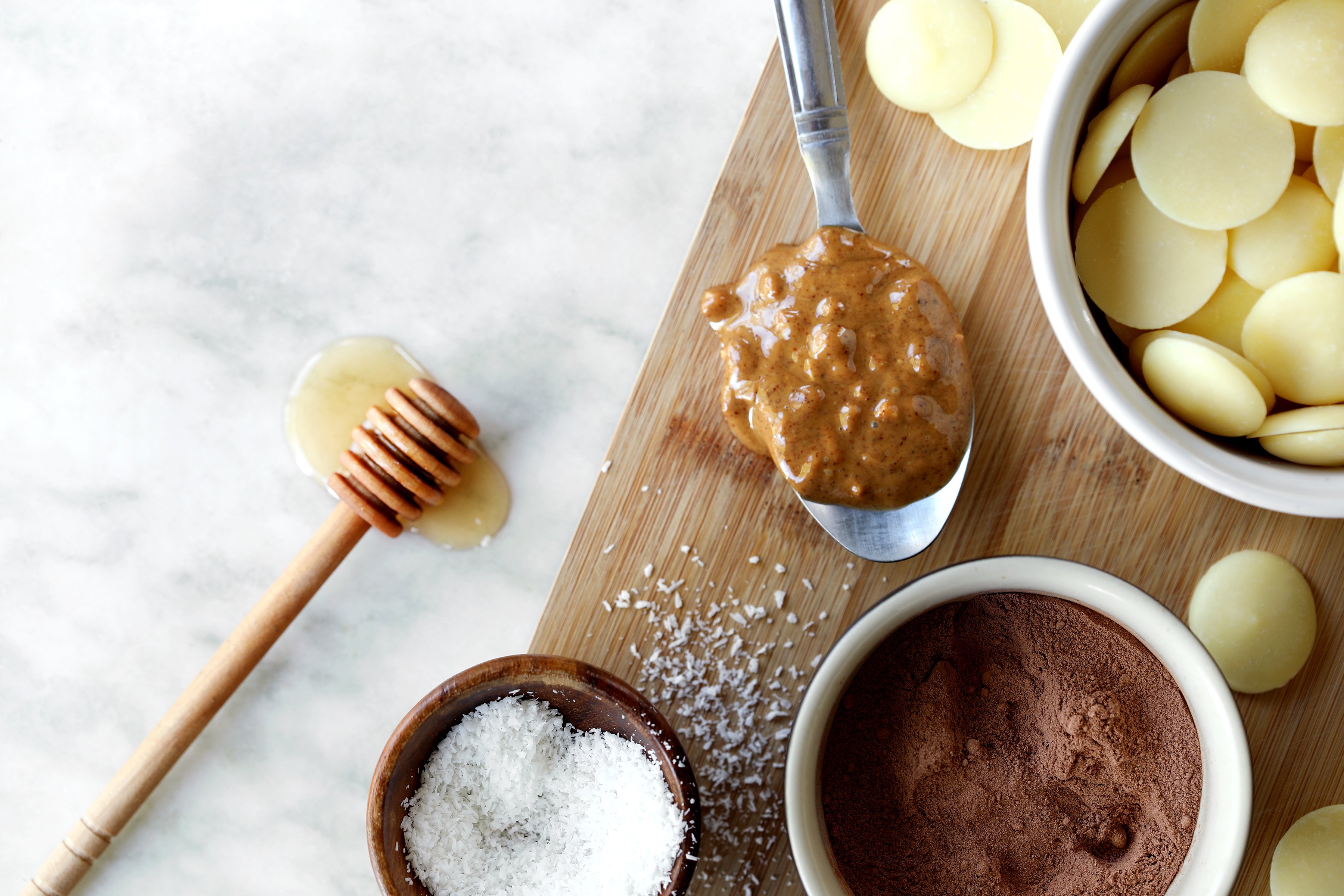 Ingredients for making herbal chocolate bars include organic raw cocoa wafers, roasted cocoa powder, organic local honey, and almond butter. 