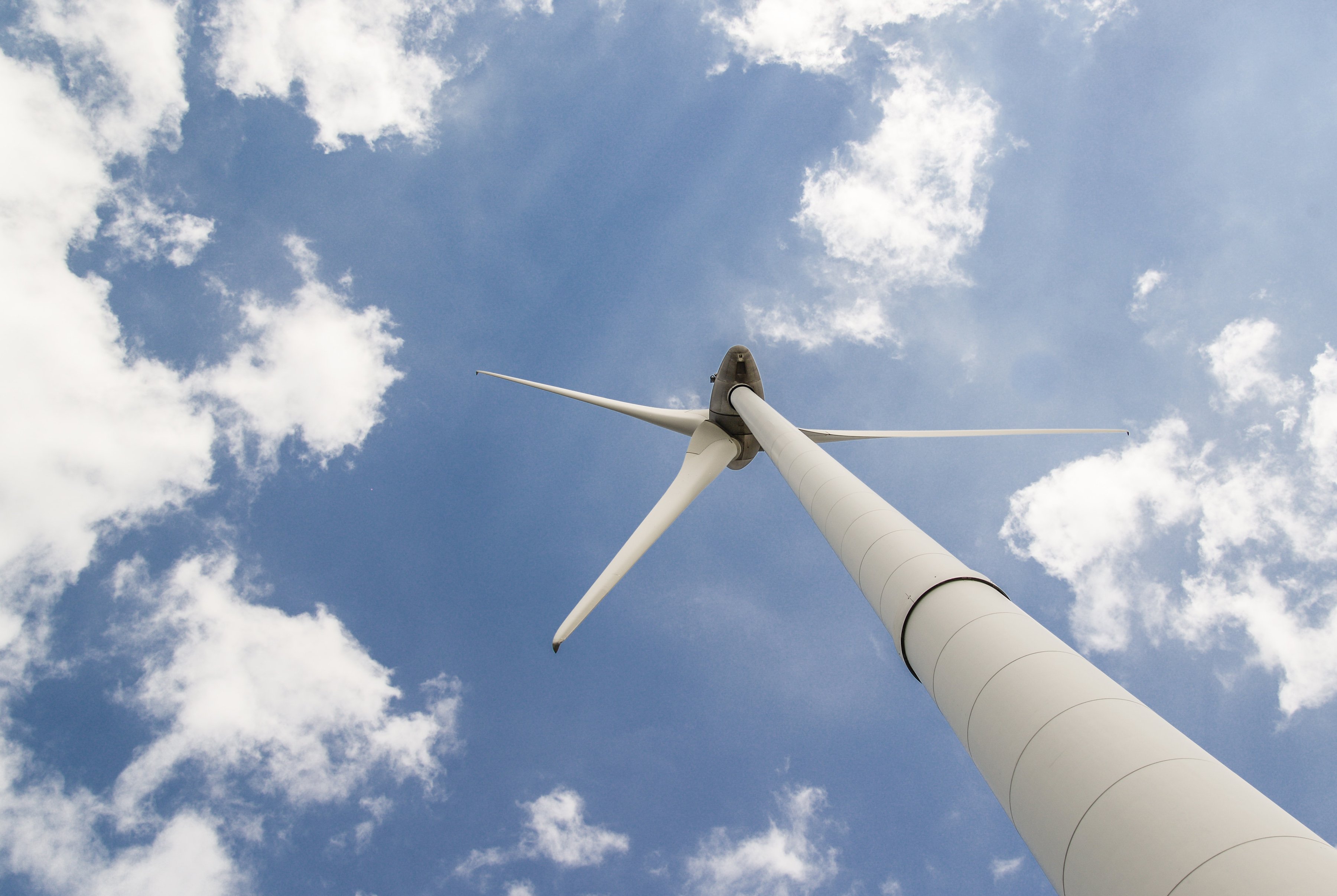 Wind turbine against a bright blue sky.