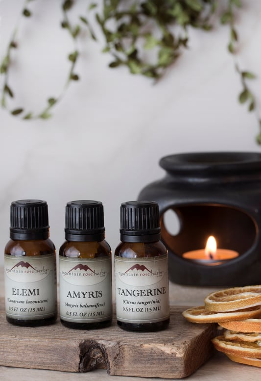 Amyris Essential OIl and other Essential Oils for Diffuse Blend in front of ceramic diffuser
