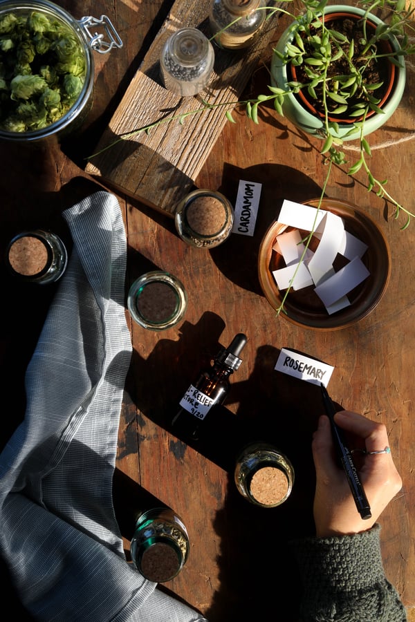 A person labeling the herbs and spices in their home herbal apothecary