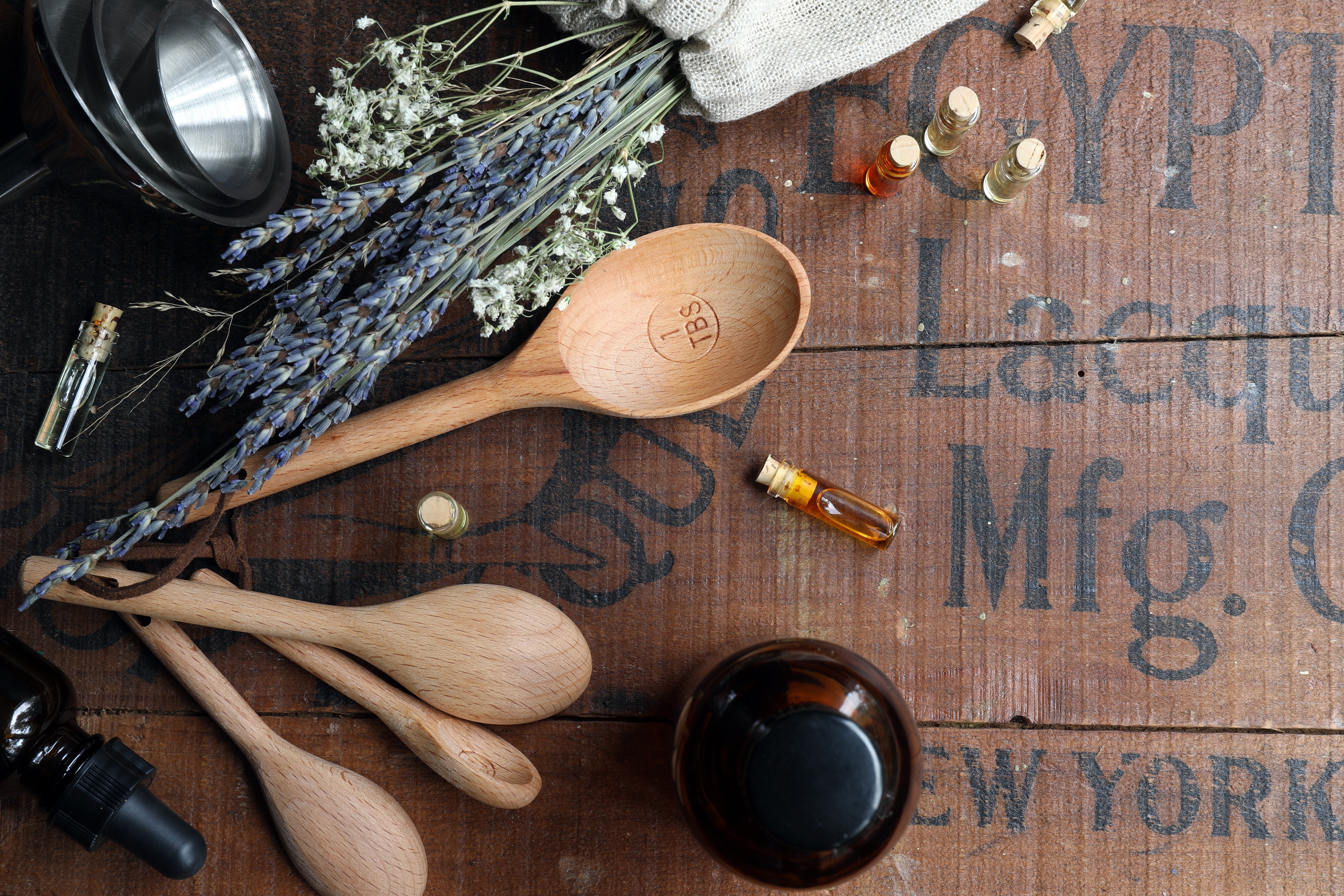 Wooden spoons laying hout year essential oils and dried lavender and other herbal tools