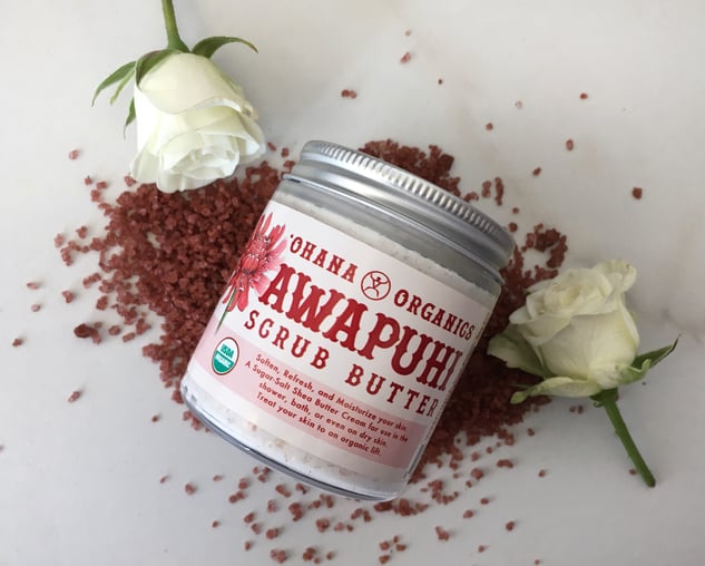 Awapuhi Butter Scrub Butter Jar sitting on Red alaea salt and white roses