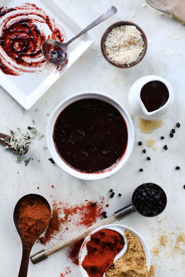 Ingredients assembled for an herbal bbq sauce. Bilberries, sage, paprika, minced garlic, honey, and chipolte powder come together to create a dark and delicious bbq sauce.