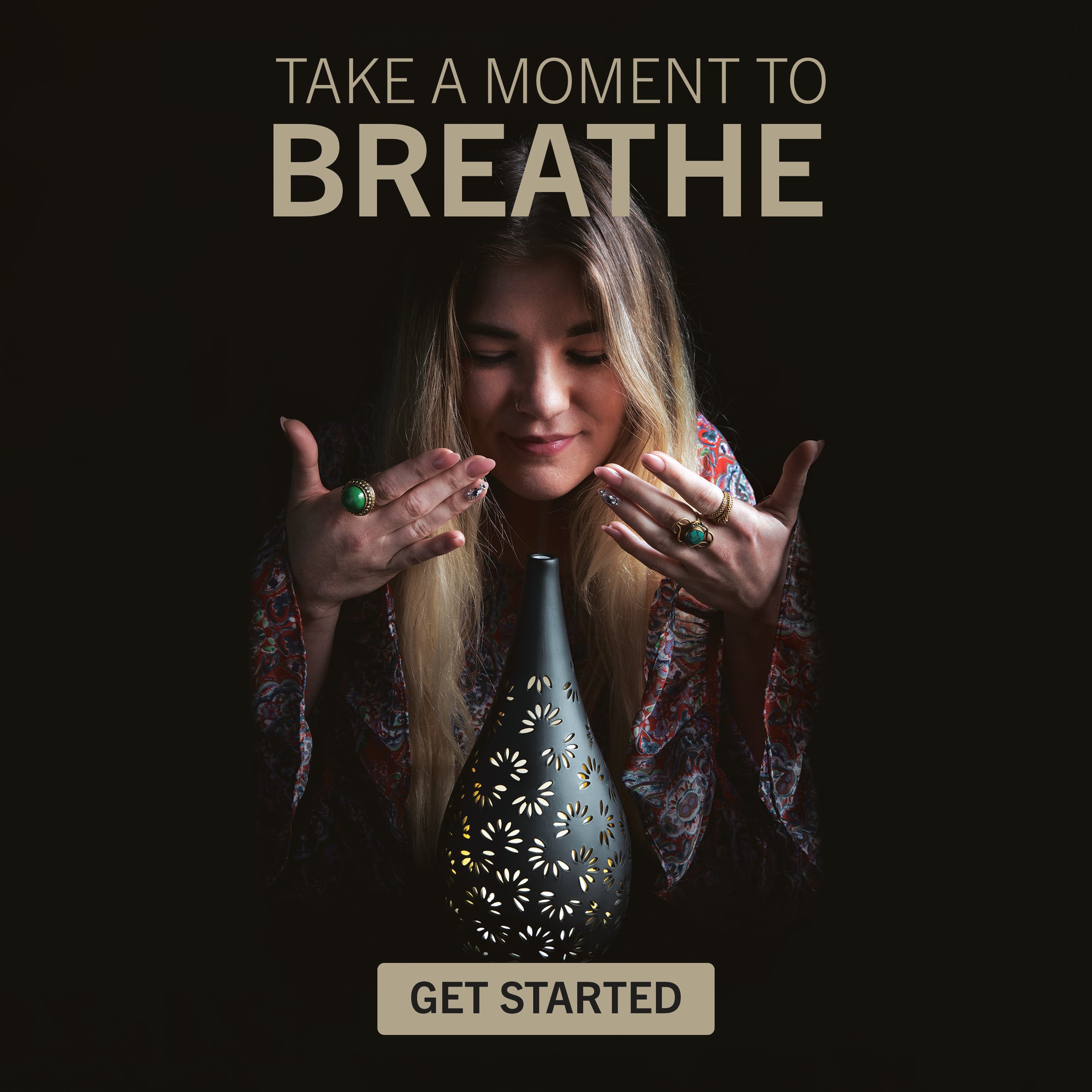 Woman breathing in mindfully next to an essential oil diffuser. 