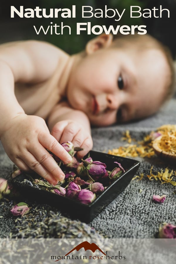 Baby playing with bath herbs and flowers.