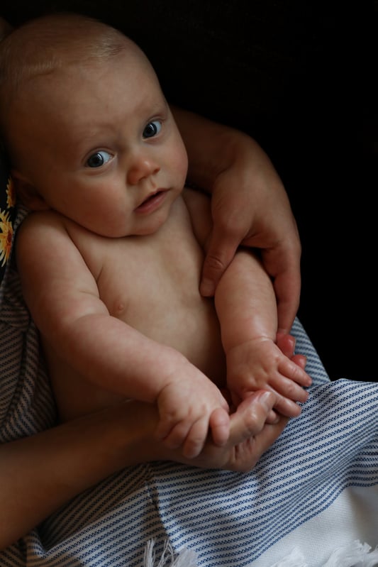 Baby receiving massage with infused oil.