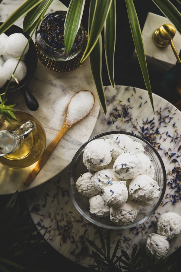 Display of bath truffles in a bowl surrounded by ingredients. 