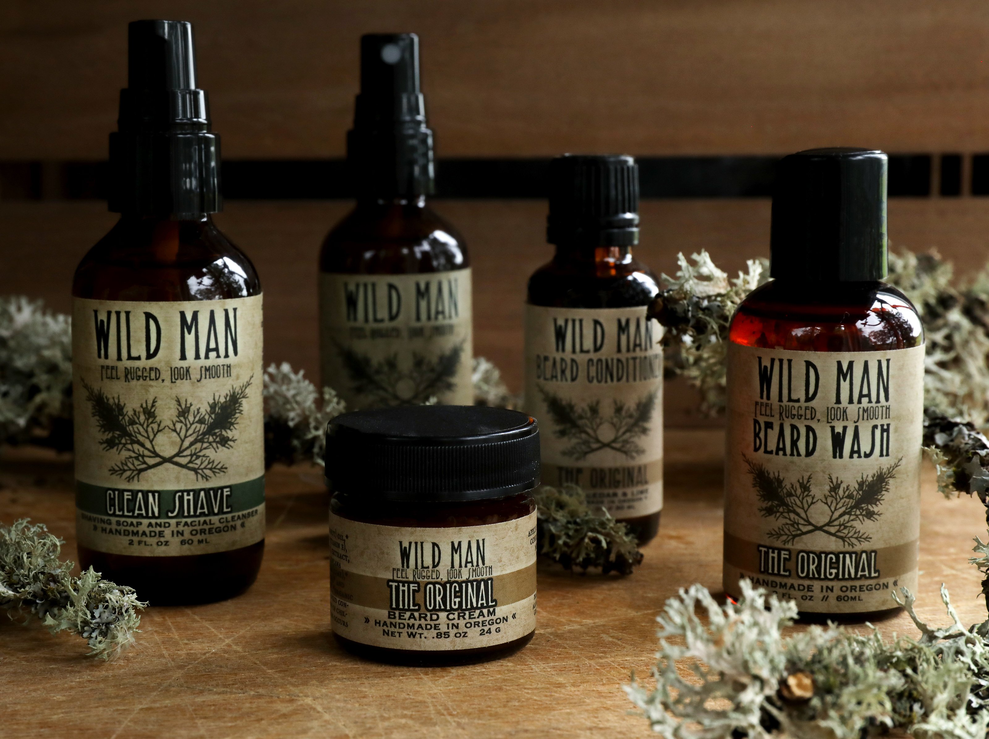 A collection of Wild Man herbal products for men assembled among dried branches with white lichen. 