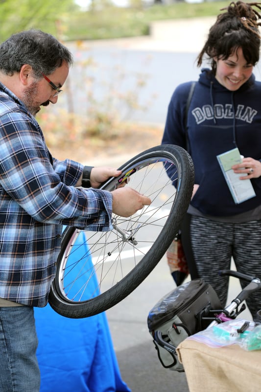 MRH employee with hands on bike wheel for safety check and bike tune up