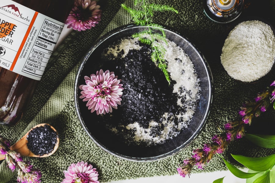 Bentonite clay and black lava salt sit in a bowl ready to be mixed with acv and essential oils