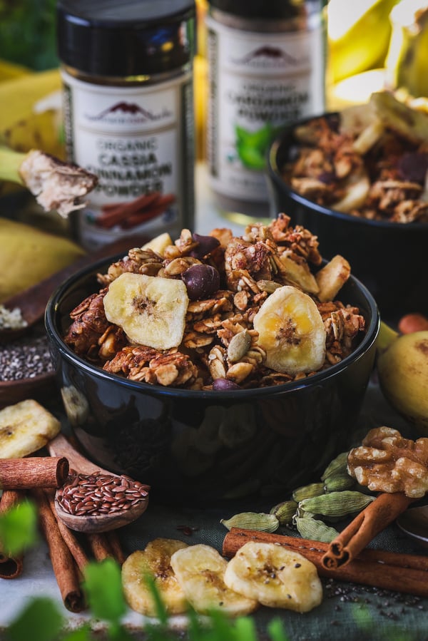 Close up of banana bread granola in bowl with ingredients around it