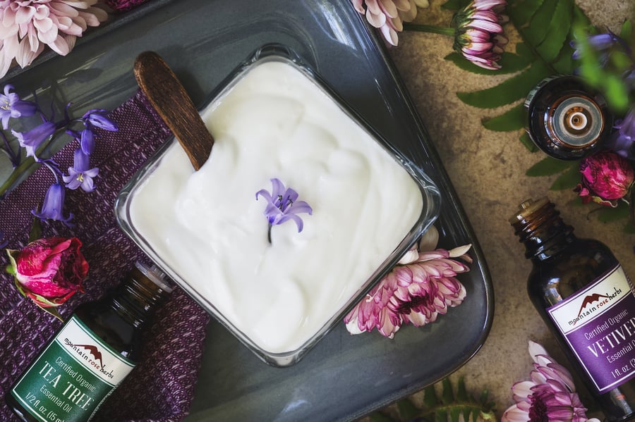 An overhead view of a dish of body lotion with awakening essential oils next to it 