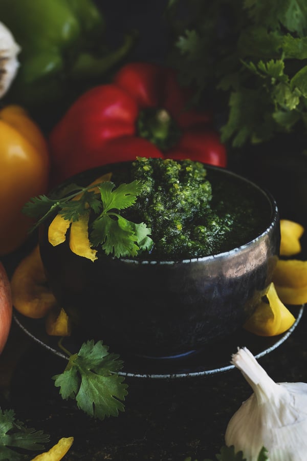 A bowl of fresh sofrito surrounded by veggies