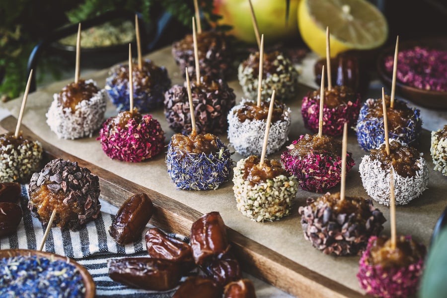 A tray of caramel apple bites with a variety of herbal toppings