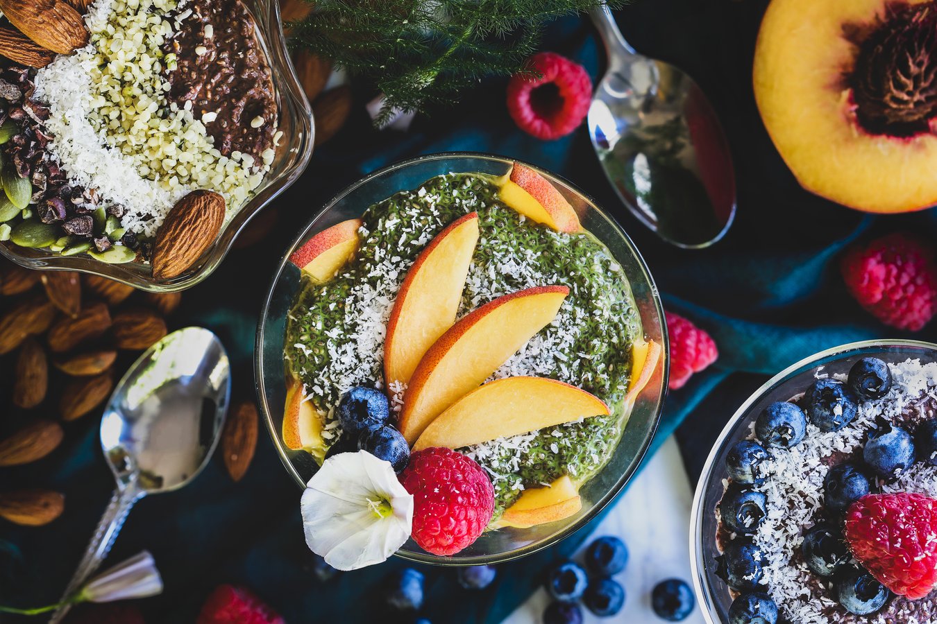 Three bowls of colorful chia puddings with fresh fruit and vibrant toppings. 