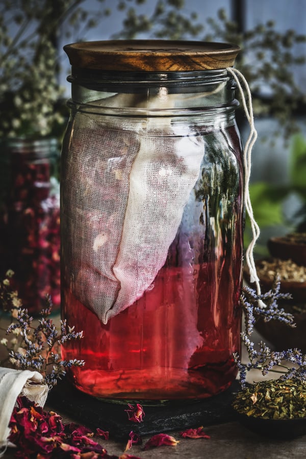 A jar with an herb filled tea bag infuses