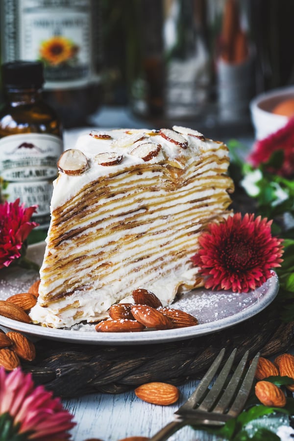A close up photo of a slice of almond cream crepe cake