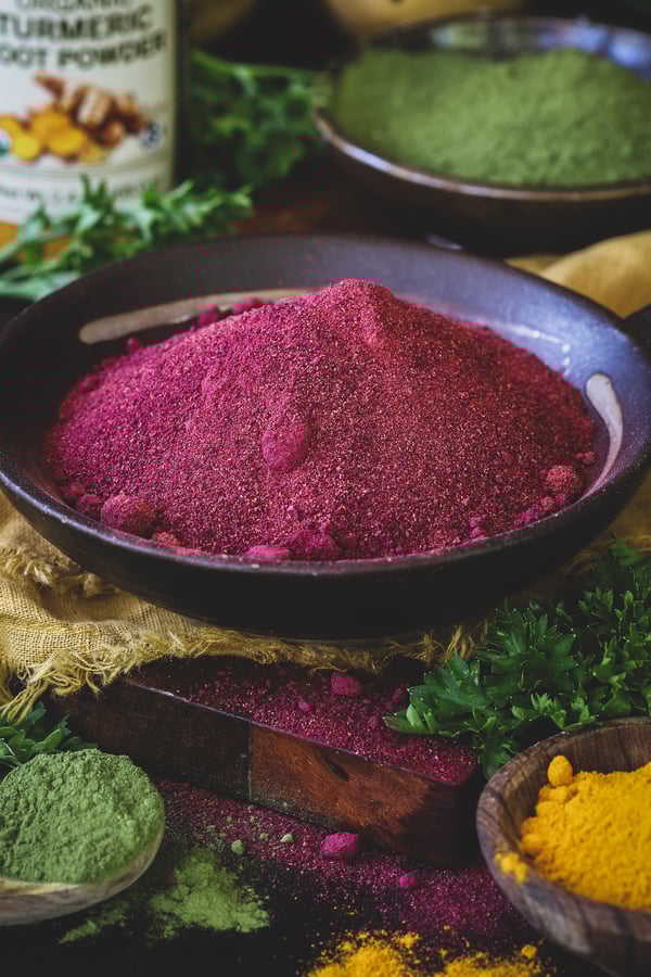 A close up photo of several colorful herbal powders