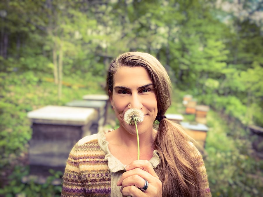 Erika Galentin holds a dandelion in front of her face