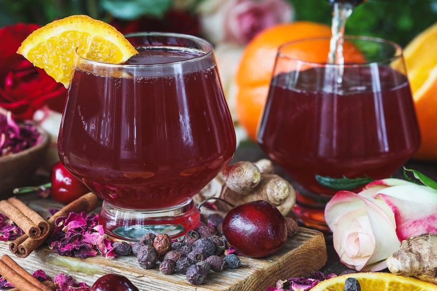 A photo of two valentine's day mocktails with fresh and dry ingredients around them