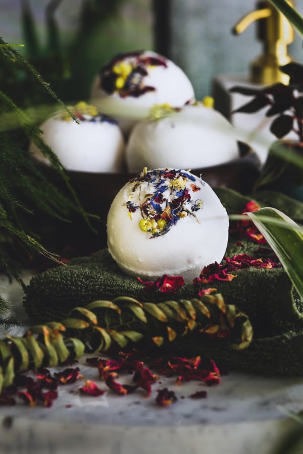 Pretty floral bath bombs surrounded by flower petals. 