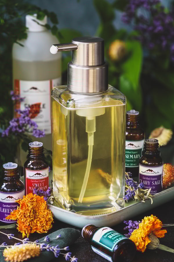 A full pump bottle filled with garden scent foaming soap with essential oils around it