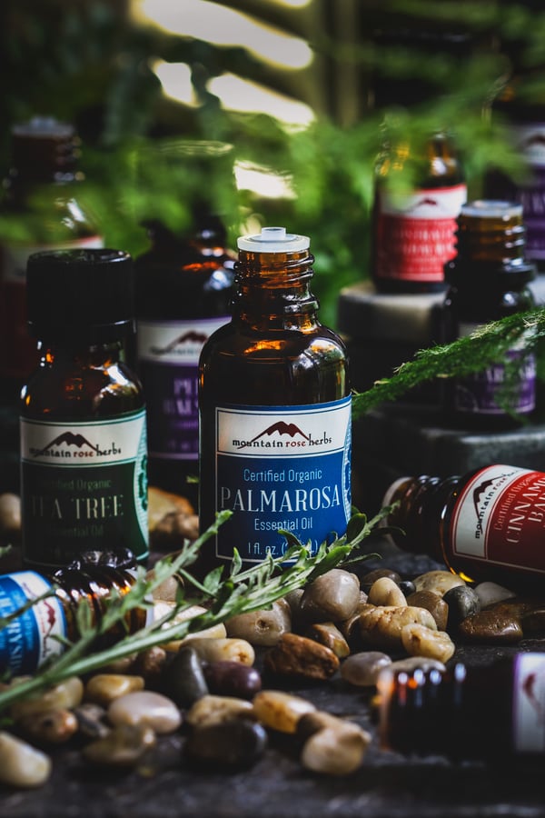 Bottles of Essential oils including palmarosa in foreground. 