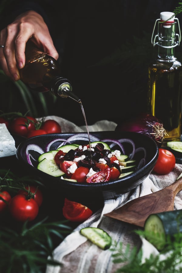 Olive oil and vinegar is drizzled on a Greek salad