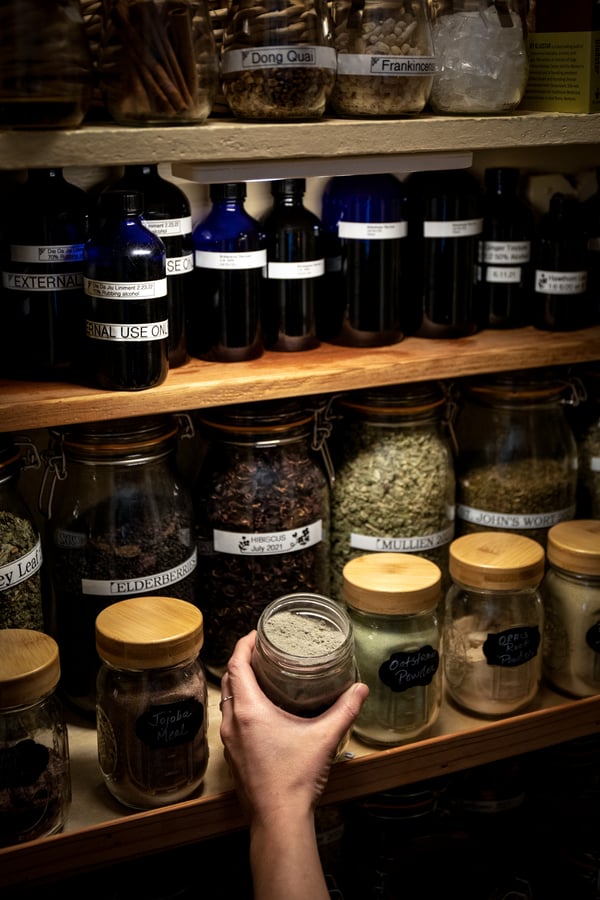 Home apothecary with jars of herbs and diy herbal formulations