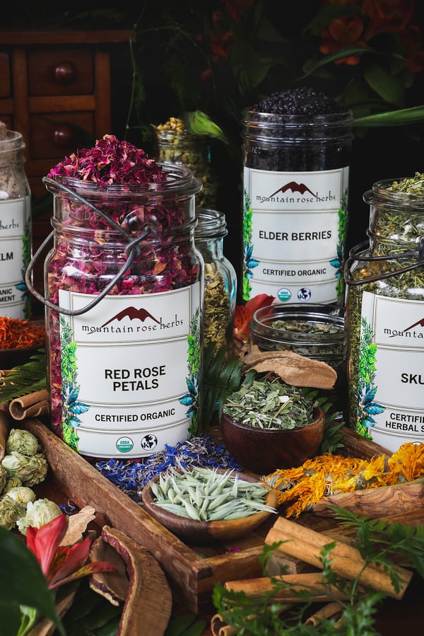 An assortment of bulk dried herbs in jars with labels on them