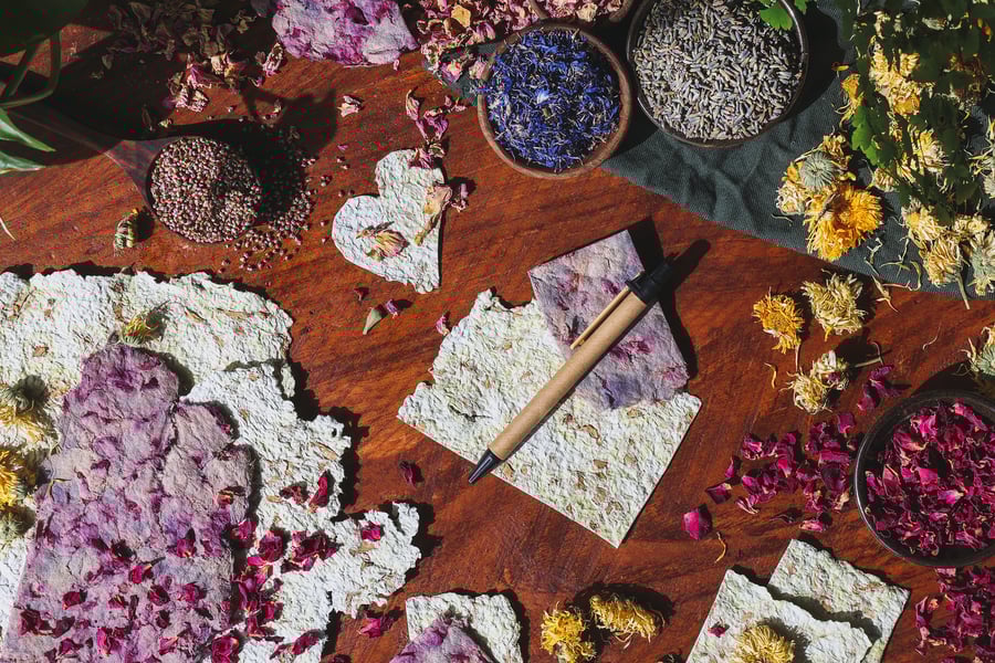 An overhead photo of homemade paper with dried flowers around it