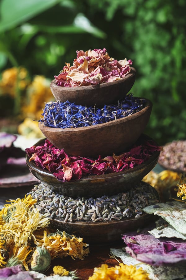 A stack of small bowls with assorted dried flowers in them 