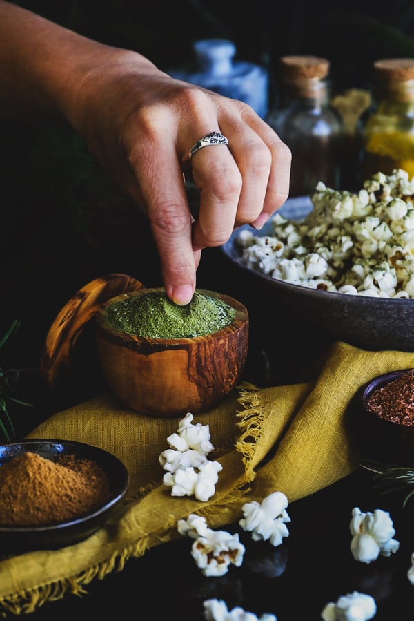 An herbal kale powder seasoning is sprinkled on popcorn