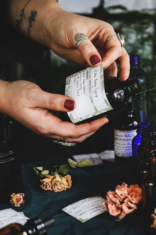 A photo of a homemade herbal syrup being labeled