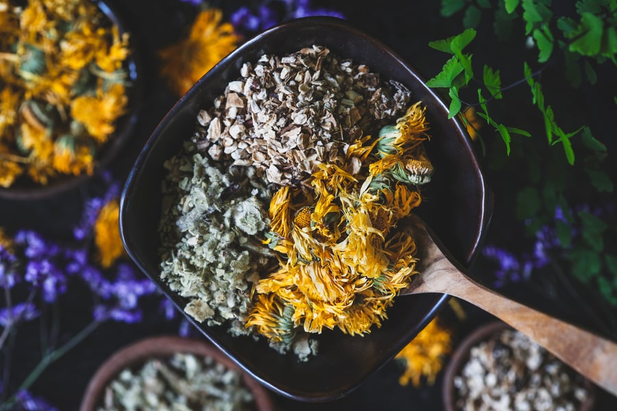 A bowl with burdock, calendula, and mullein in it