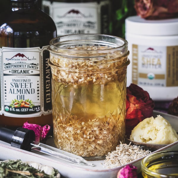 A jar of marshmallow root tea and other ingredients to support high porosity hair