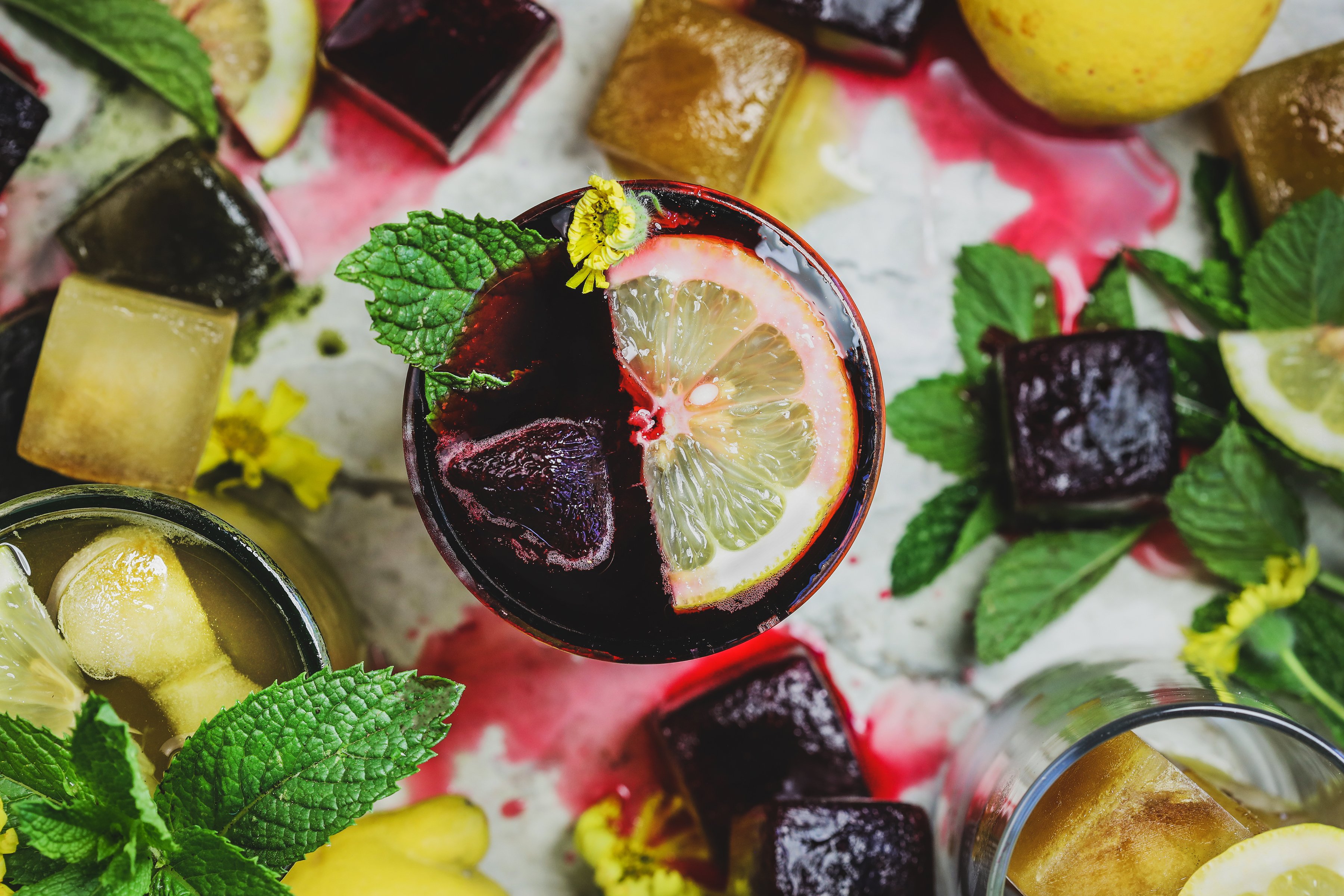 Colorful ice cubes surrounded by fresh ingredients. 