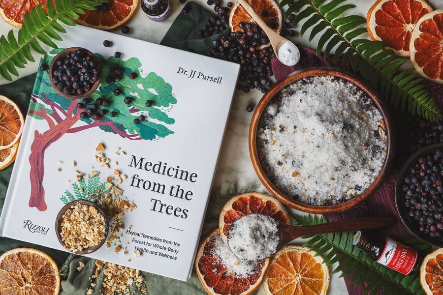 An overhead photo of Medicine from the tree book alongside bath salts and dried herbs