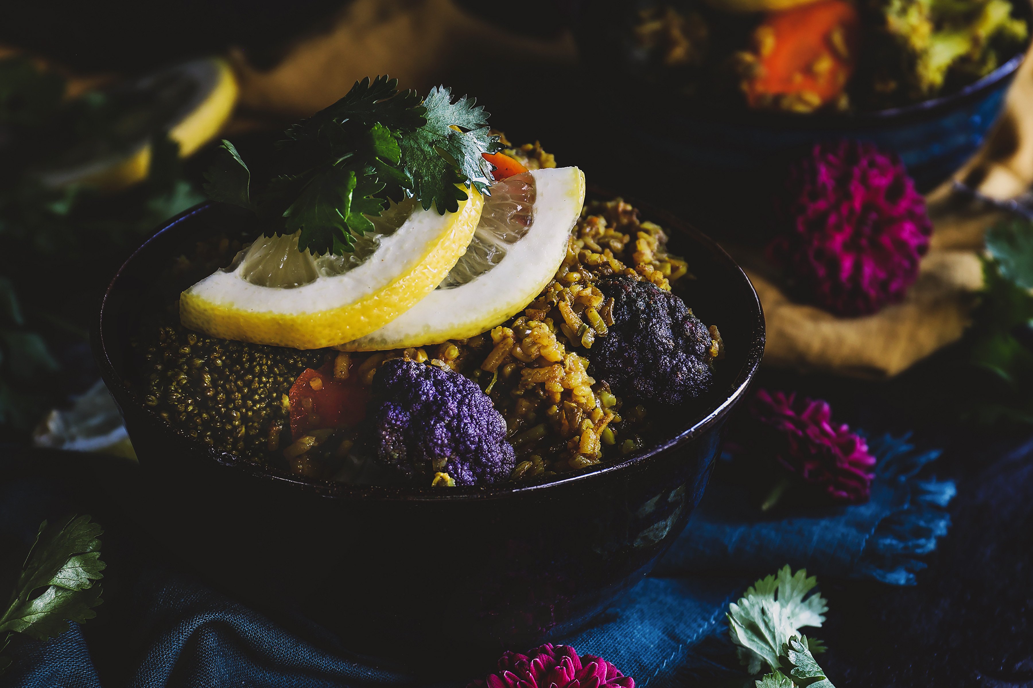 A colorful bowl of kitchari topped with fresh lemon and cilantro. 