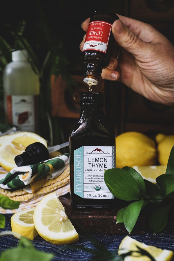 Lemon essential oil being dropped into lemon thyme hydrosol