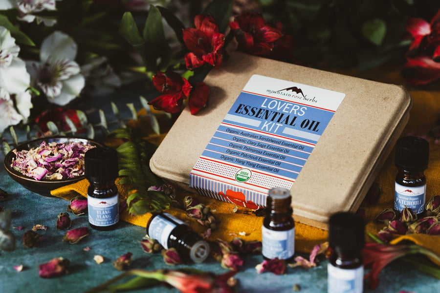 A photo of the mountain rose herbs lovers essential oil kit with bottles and rose petals around it