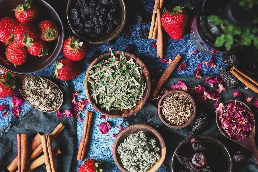 An overhead photo of bowls of dried herbs and fruit used in cordial recipe