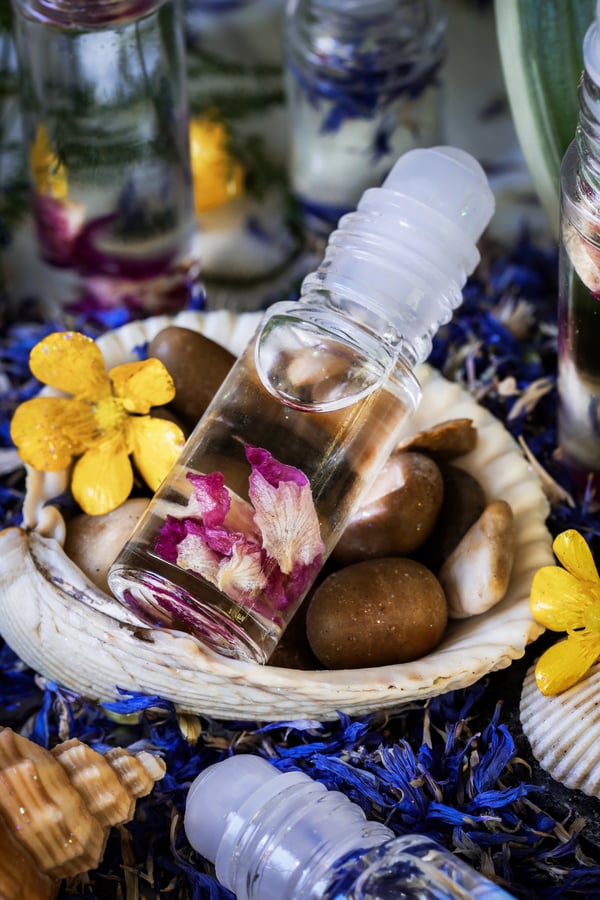 A blend of mermaid perfume in a bottle with rose petals