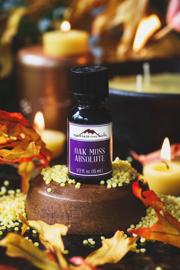 An oakmoss essential oil with candle ingredients around it