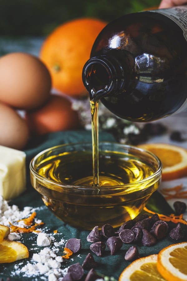 Olive oil being poured into bowl with baking ingredients around it