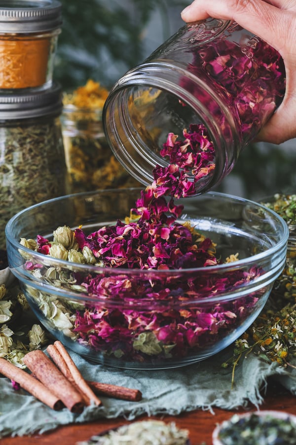 A jar of old rose petals gets emptied out into a bowl