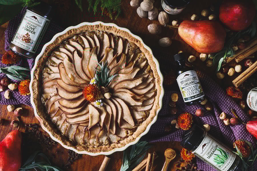 An overhead photo of hazelnut pear tart with ingredients around it 
